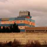Adiacente al parcheggio si trova un altro edificio a fasce blu e arancione sbiadite: svetta alto ma � anch�essa in disuso. Si tratta della vecchia sede del negozio di mobili �Nuova Arredo�, l�ennesimo capannone abbandonato